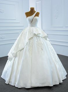 a white wedding dress on display in a room