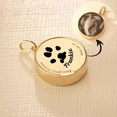 an image of a dog's paw print on the back of a gold pendant