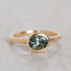 a gold ring with a green stone in the center