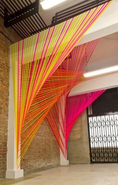 an image of a room that has been decorated with bright colored sticks and wires on the ceiling