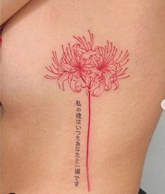 a woman's stomach with a flower tattoo on her side and the words written in japanese