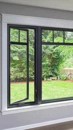 an open window in a room with green grass and trees behind it, overlooking a back yard