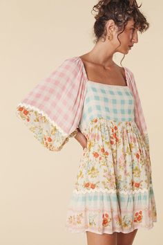 The Flora Tunic Dress in Pastel is a charming new style for Spell. Unassuming and romantic, we imagine our muse twirling through fields of florals or daydreaming by a woodland stream. Our Tunic Dress features a flattering square neckline with elastic shoulder straps and elasticated sleeve cuffs. An effortless beauty, The Flora Tunic can be thrown over head and worn to the beach, to brunch or to that elegant garden soiree. A cotton rick rack detail at the sleeve and skirt, the checkered print in Outfit Ideas With Dresses, Pastel Fits, Apparel Boutique, Diy Vetement, Effortless Beauty, Sorority Outfits, Church Outfits, Catamaran, Look At You