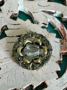 This brooch is a lovely antique one.  It is in great codnition for its age.  This brooch has a clear quartz crystal stone, with gorgeous ornate detailing all the way round it.  This brooch has a lovely size, with a diameter of approximately 3cm.  It is lovely and light weight as well.  If you love this and feel the price is a little out of reach, please pop me a message and we can sort something out. Vintage Gemstone Brooches For Formal Occasions, Handmade Vintage Brooch For Anniversary, Handmade Vintage Brooches For Anniversary, Vintage Silver Brooch With Gemstone, Vintage Silver Gemstone Brooch, Antique Bronze Brooches For Collectors, Antique Bronze Collectible Brooches, Victorian Brass Brooches For Formal Occasions, Victorian Brass Brooch For Formal Occasions