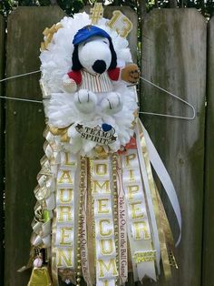 a stuffed animal hanging from a fence with ribbons around it's neck and head