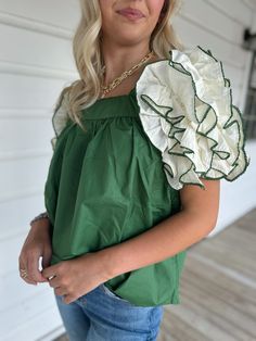 Adorable green top with off white ruffle sleeve detailing Model is 5’4” with a 25” waist, 32” bust and 32” hips wearing a small. Dark Green Cotton Top For Spring, Dark Green Cotton Tops For Spring, Chic Green Puff Sleeve Top, Green Short Sleeve Blouse For Brunch, Summer Green Cotton Puff Sleeve Top, Green Cotton Puff Sleeve Top For Summer, Green Puff Sleeve Top For Spring Day Out, Chic Green Puff Sleeve Blouse, Fitted Dark Green Top For Spring