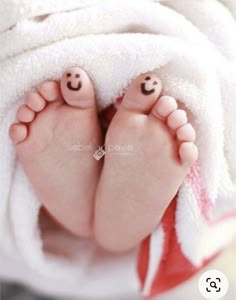 a baby's feet covered in a towel with smiley faces