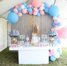 a woman standing in front of a table with cake and balloons