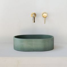 a bathroom sink with gold faucet and soap dispenser on the wall