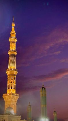 a tall tower with a clock on it's side at night in the city