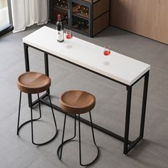 two stools sitting at a table with wine bottles on it