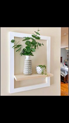 there is a white shelf with some plants on it