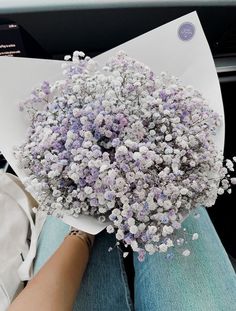 a bouquet of flowers sitting on top of a white piece of paper in someone's lap