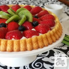 a fruit tart with kiwis, strawberries and blueberries on top