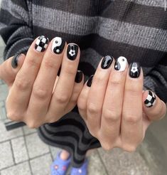 a person with black and white nail polish holding their hands