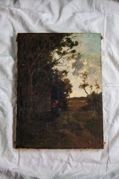 an old painting on a white sheet with trees and people in the woods behind it