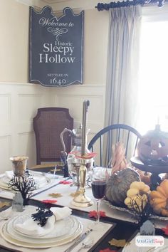 a dining room table set for halloween dinner with plates and place settings on the table