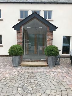 a house with two large planters in front of it and a car parked outside