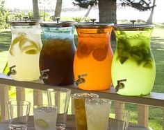 four different colored drinks are lined up on a table