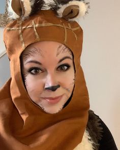 a woman wearing a cat costume with her face painted like a racoon