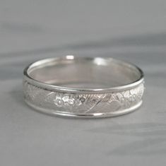 an engraved wedding band is shown in white gold, with floral engraving on the side