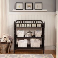 a shelf with baskets and stuffed animals on it next to a rug in a room