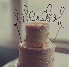 a cake with the word hello written on it in cursive writing, sitting next to a window