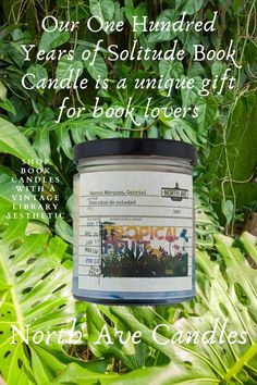 a candle that is sitting in the middle of some plants with words about it on it