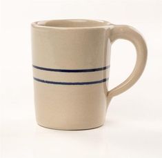 a white and blue striped coffee mug on a white background with the bottom half painted off