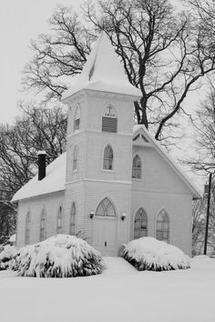 a white church with snow on the ground