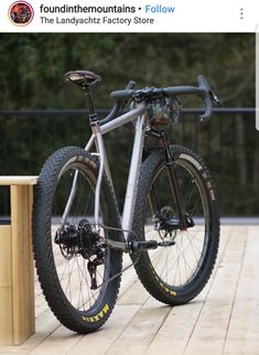 a bicycle is parked on the side of a wooden bench