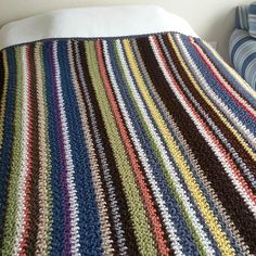 a crocheted blanket sitting on top of a bed