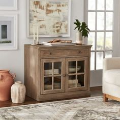 a living room scene with focus on the cabinet and vases in the foreground