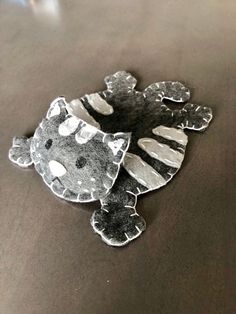 a close up of a cat shaped object on a table with black and white spots