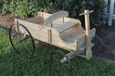 an old fashioned wooden wagon sitting in the grass