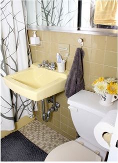 a yellow sink and toilet in a small bathroom