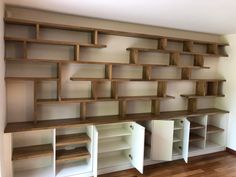 an empty room with shelves and cabinets on the wall in front of wood flooring