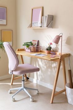 a desk with a chair, potted plant and pictures on the wall