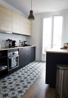 a kitchen with black and white tiles on the floor