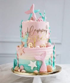 a pink and blue birthday cake sitting on top of a table