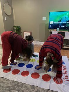 three children are playing with giant polka dots on the floor in front of a tv