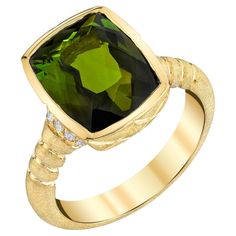 This beautifully designed ring features a 4.40 carat cushion-cut green tourmaline set in a handmade 18k yellow gold bezel with sparkling diamond accents. The center stone has bright, medium green color and "brilliant cut" faceting that gives the gem such sparkle! The ring has an elegant Florentine finish created entirely by hand using old world, artisan techniques and skill rarely seen today. A gorgeous geometric pattern gives the finish a lovely "pillowy" appearance, adding texture and a rich f Green Rings, Green Cushions, Cushion Diamond, Sparkling Diamond, Green Gems, Green Tourmaline, Green Stone, Sparkle Diamonds, Round Brilliant Cut Diamond