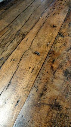 an old wooden floor with peeling paint on the top and bottom part of it's surface