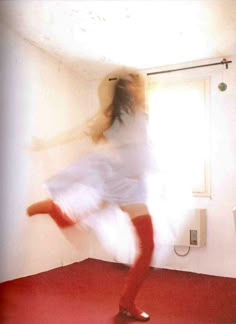 a blurry photo of a woman dancing in a room with red carpet and white walls