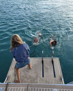 two people are swimming in the water on a dock with no one is wearing a life jacket