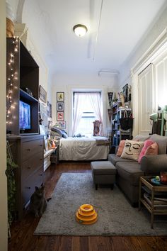 a living room filled with furniture and a flat screen tv on top of a wooden floor