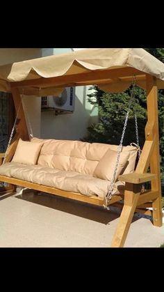 a wooden porch swing with cushions on the bottom and side swings attached to the sides