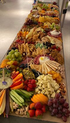 a long table filled with lots of different types of fruits and veggies on sticks