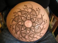 a pregnant woman's belly with an intricate design on it