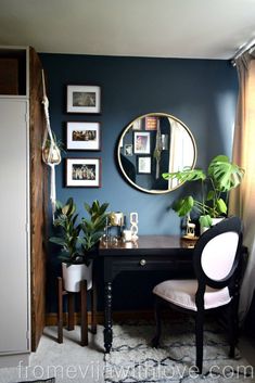 a room with a desk, mirror and plants